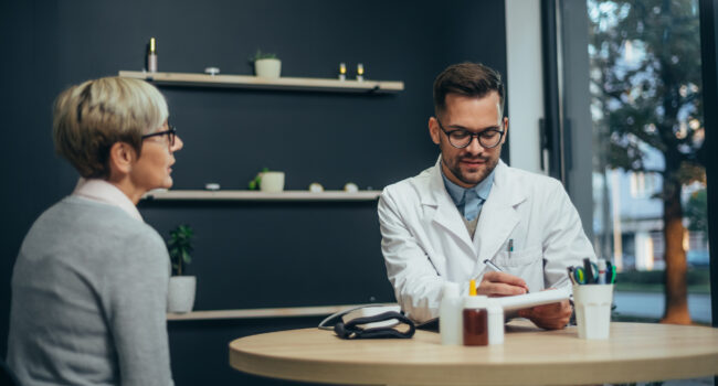 Doctor in consultation with a senior patient Smiling male doctor in consultation with a senior woman patient in a modern office